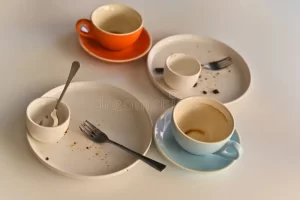 Dirty dishes at a coffee shop sitting on a table.