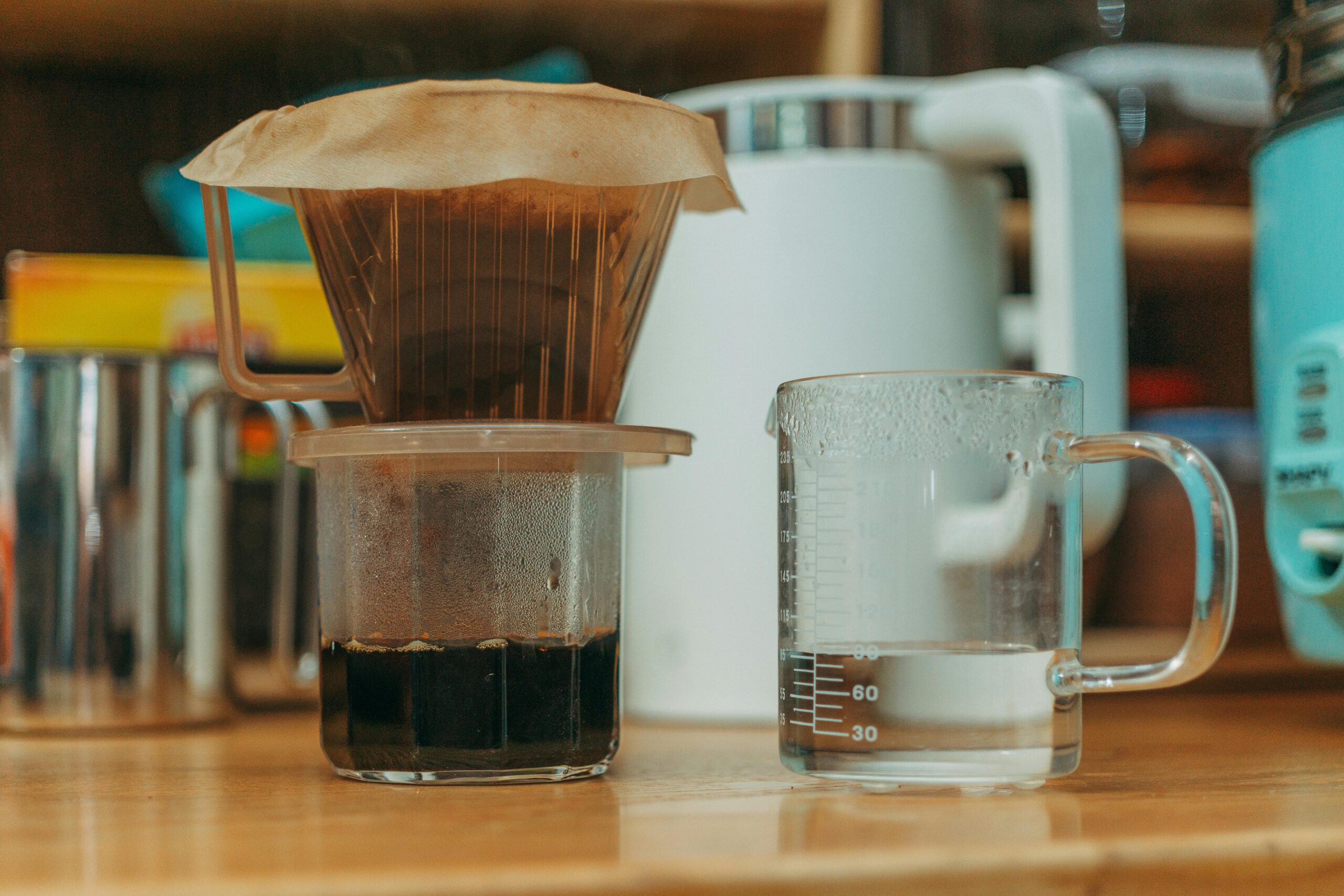 Close-up of a pour over coffee setup with water in a glass, emphasizing home brewing methods.